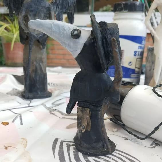 Figura de un médico de la peste con máscara de pico, en el taller